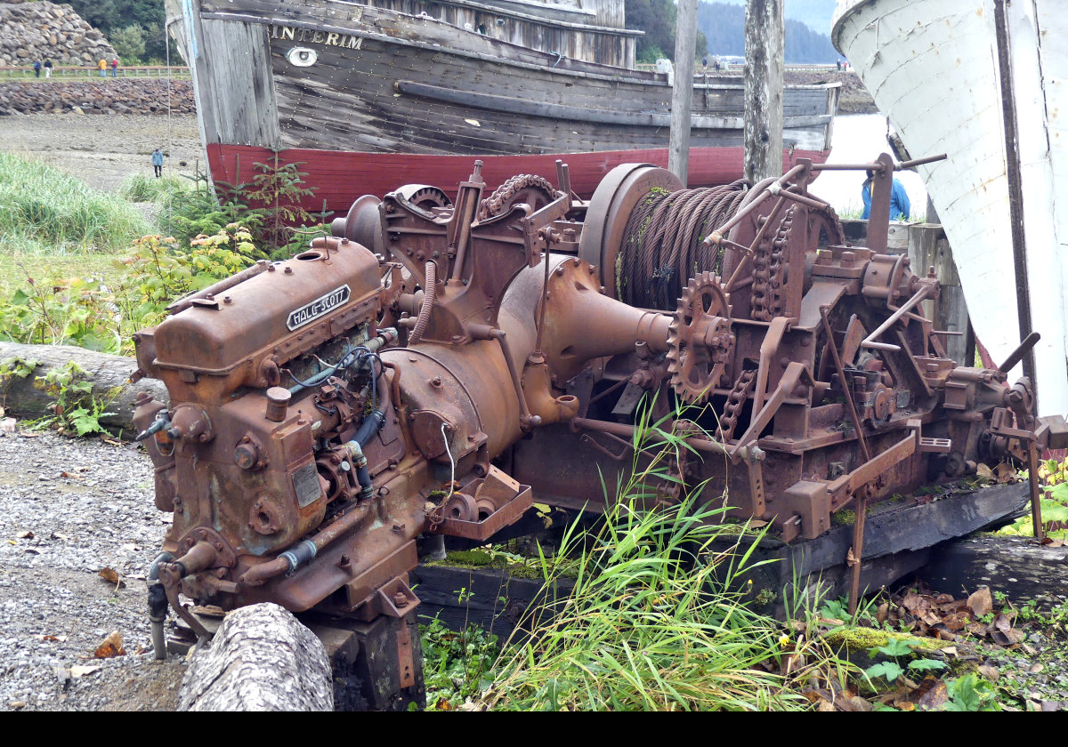 An old Hall Scott engine, possibly a water cooled airplane engine, a type for which they were well known.  Now looks to be powering a large winch.