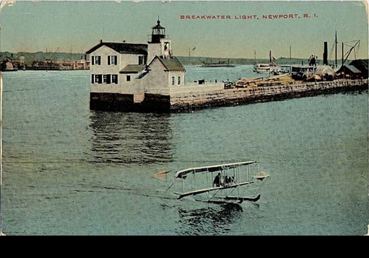 This photograph is from a period postcard dated around the same time that was actually posted in 1912. It shows the breakwater before the land was filled in. I love the tiny bi-plane in the foreground!