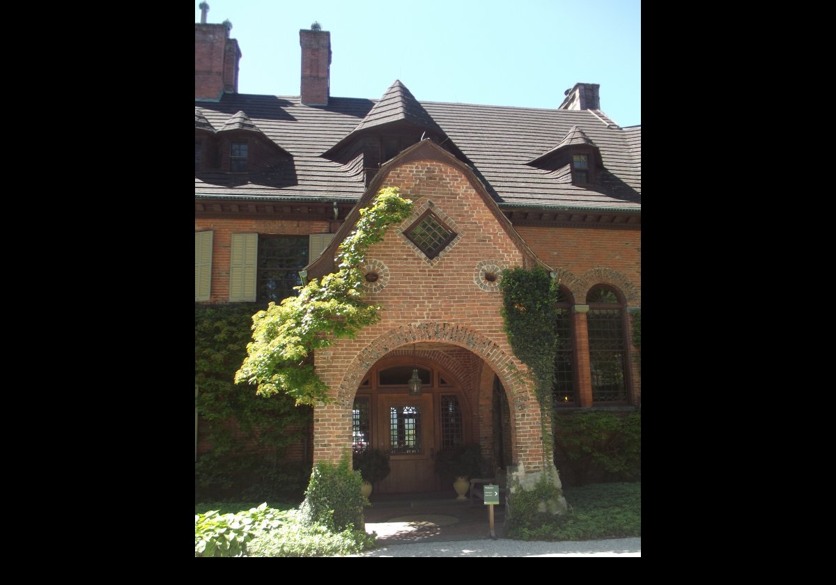 The wood-shingle exterior of the house includes towers constructed from brick & stone, as well as a number of asymetrical gables.  There is a large porch on the rear of the house featuring extensive views of the surrounding countryside.  