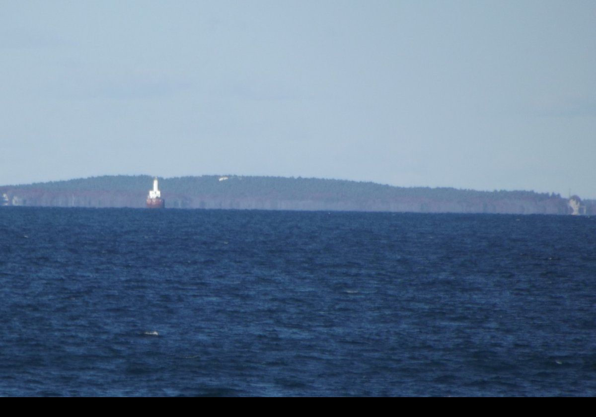 Very distant view (about 8 miles away) of the Cleveland Ledge Light, Bourne.  Area between Marion & Wareham, MA in the background.