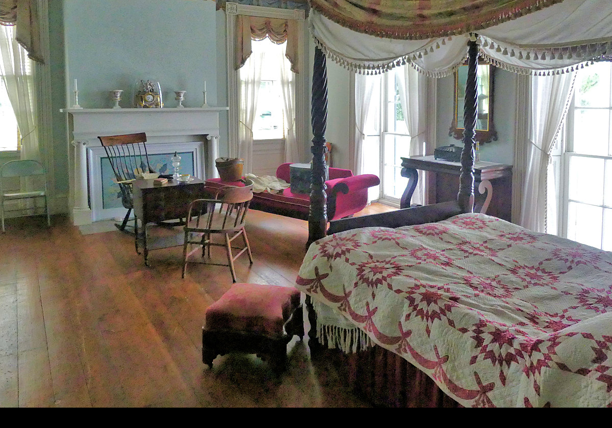 One of the bedrooms with a four poster bed and a chaise longue. Another interesting clock on the mantle. The next picture has a close-up of the clock.