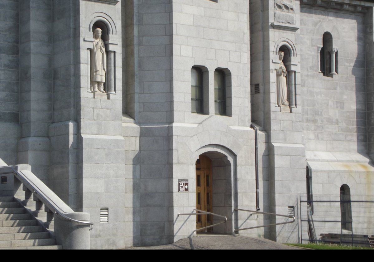 The statue on the left is of Kateri Tekakwitha (1656-1680) by Joseph-Émile Brunet.  Also known as "Lily of the Mohawks", she is a Roman Catholic saint.