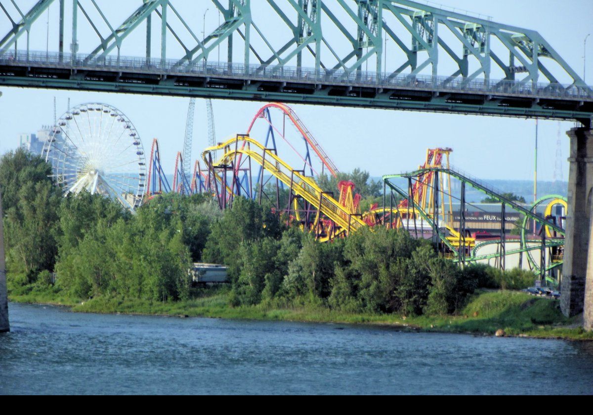 The Jacques Cartier Bridge with the La Ronde amusement park visible underneath.  The park opened in 1967 and is on 146 acres on Sant Helen's Island.  Since 2001, it is owned by Six Flags, though not branded as such.  Among the 40 rides there are 10 roller coasters, with Le Monstre being the highest double-tracked coaster in the world at 40 meters (over 130 feet) high.