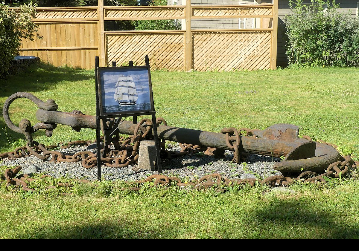 An anchor and a picture of a ship outside the Jost House Museum.  The next photograph has a closeup of the ship picture.