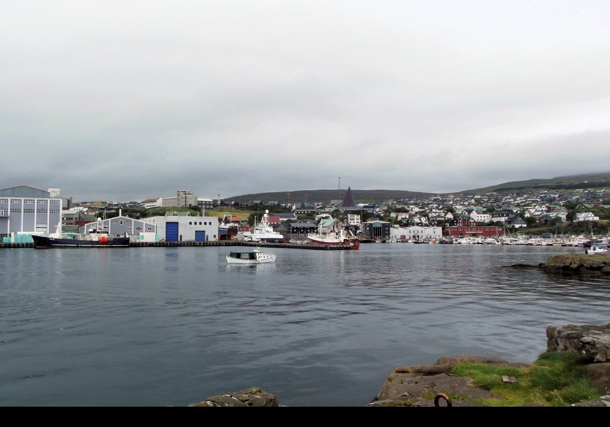 Looking across Vestaravag harbor. The next image is a close-up of the pyramid shaped copper spire of the Vesturkirkjan (the West Church). Built in 1975, it is the tallest church in the Faroe Islands.