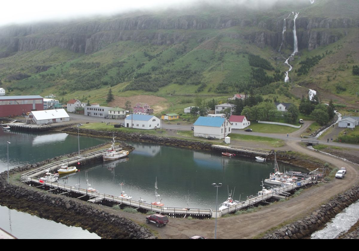 A small marina at the end of the fjord. Note the waterfall tumbling down behind.