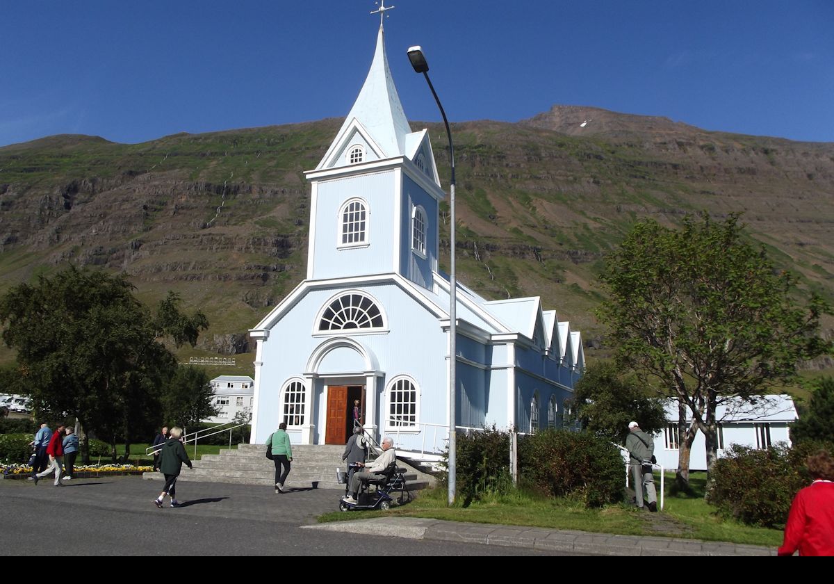 Arriving at Seyðisfjarðarkirkja; the Blue Church. The road to the church is now painted in bright colors. It is called Regnboga Vegur or Rainbow Road.