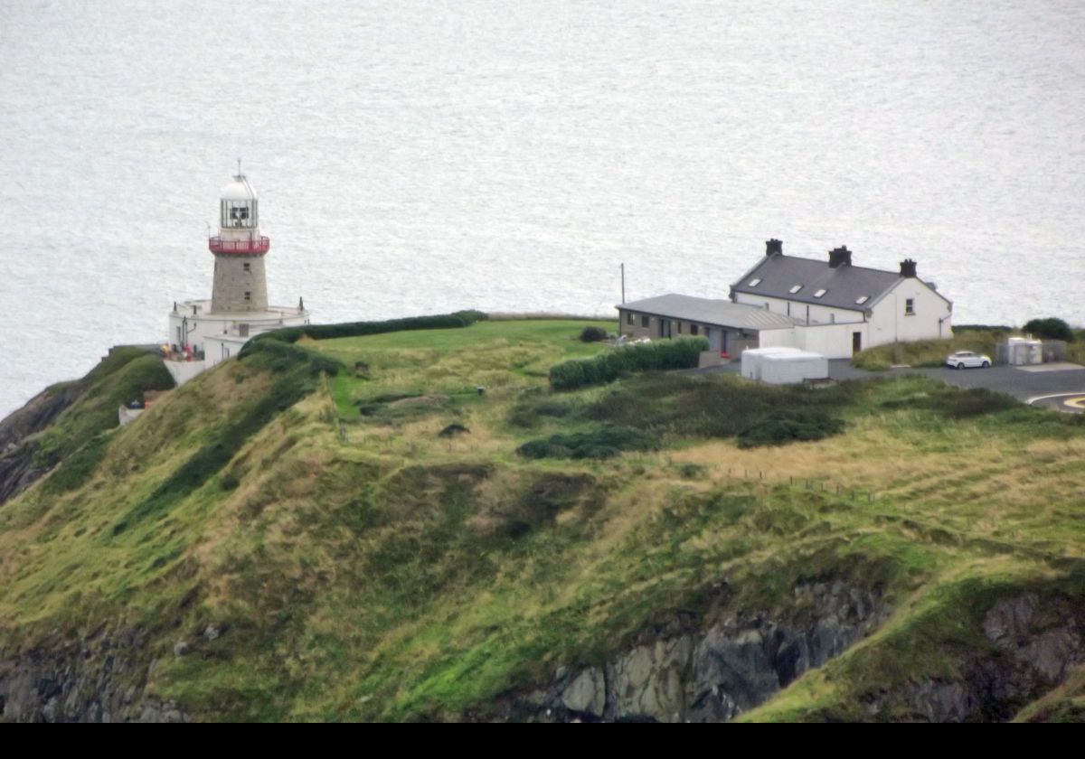 The Baily Lighthouse; built in 1814. It comprises a round, unpainted granite tower with a white lantern and gallery with a red railing.  It sits on a round keeper's house on the southeastern tip of the Howth Peninsula.  Between 1902 and 1972 it used a 1st order Fresnel lens