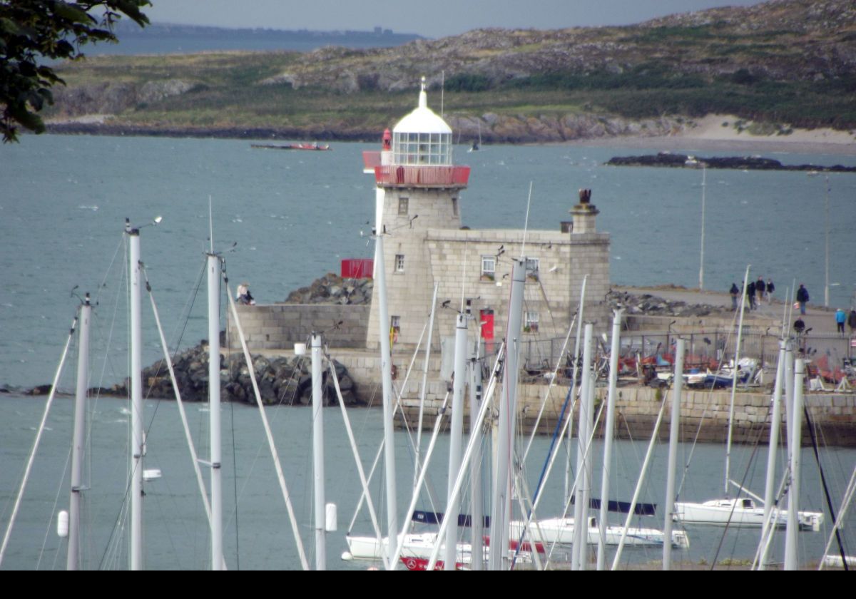 The Howth Harbour lighthouse was established in 1818. It has a 10 m (33 ft) round cylindrical concrete tower with gallery having a red railing.