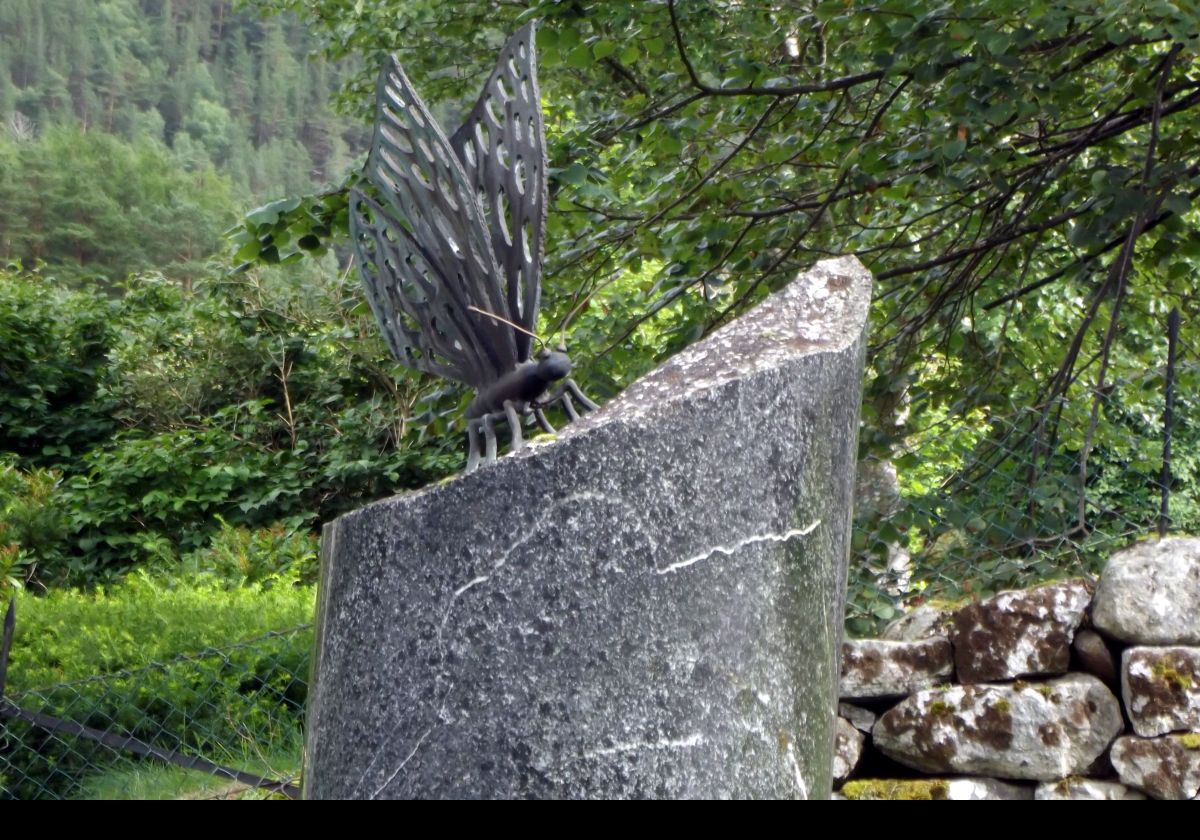 A sculpture near the old church. The pedestal is inscribed with the motto of the Norwegian armed forces "for fred og fridom" meaning "for peace and freedom".