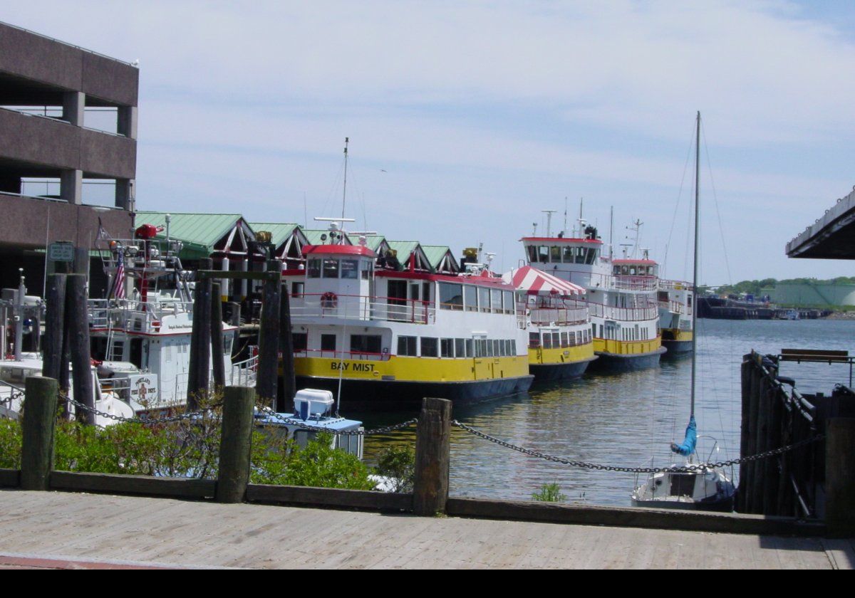 On the left, (green roof) is part of the Maine State Pier complex, with one of the Commercial Street docks in front.  
