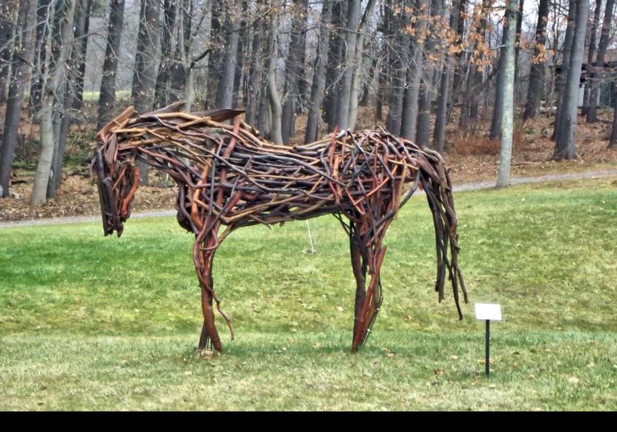 Outside the museum, there is a horse sculpture titled "Tres Bien". It was made from driftwood in 2014 by Rita Dee.