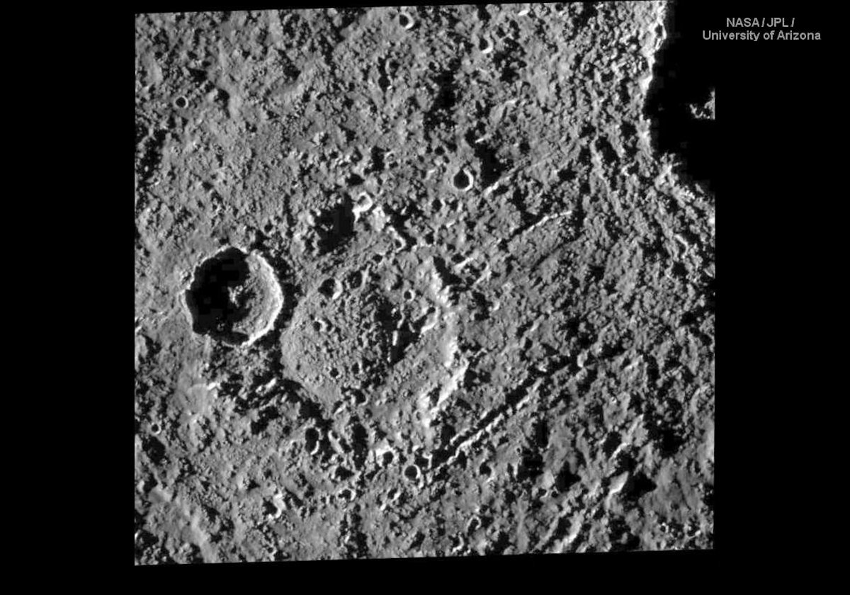 This image shows the crater Har on the left of, and below, center.  It is 50 km (30 miles) across with an unusual central rounded mound probably caused by material from below being forced upwards.  On its left edge is a newer crater about 20 km (12 miles) across.  Partially visible in the top right corner of the image is the crater Tindr.  This is shown in more detail in the next picture that was also taken by Galileo.  