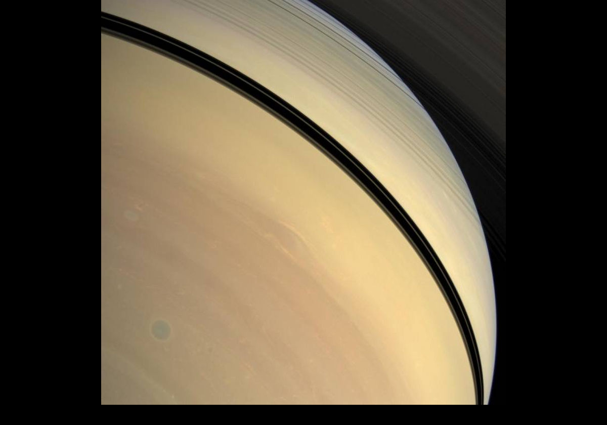 In the lower left of this Cassini image, there is a storm in the atmosphere of the southern hemisphere.  It appears as a blue circle in this true color photograph.  The view is up toward the sunlit side of the rings from about 36° below the ringplane.  